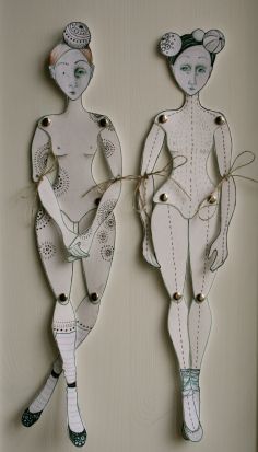 two paper cut out figures are hanging on the wall