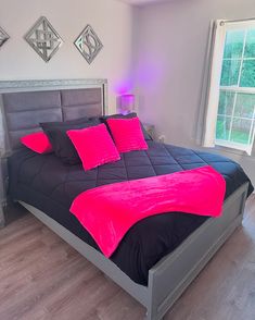 a bed with pink and black sheets in a bedroom