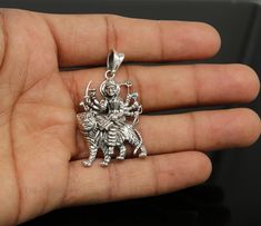 Divine 92.5 sterling silver Indian Hindu Idols Blessing Goddess Bhawani/Durga/Santoshi maa with lion vintage antique style stunning divine pendant, best gifting unisex jewelry from India. Metal-925 sterling silver. Item type-Pendant/ Locket Weight-9.250 grams. Height-4.8 centimeter. Width-2.7 centimeters. Stamped-925. Finish-Oxidized. note :chain is not include in this price, to purchase chain please visit following links: https://www.etsy.com/listing/823425858/16-to-30-long-screw-chain-925-ster Durga Maa Pendant, Symbolic Pendant Jewelry For Festivals, Heavy Jewelry Gift For Navratri, Silver Temple Jewelry Pendant, Hallmarked Jewelry For Puja And Navratri, Symbolic Jewelry For Festivals, Heavy Round Sterling Silver Jewelry, Heavy Spiritual Pendant Jewelry, Symbolic Jewelry For Puja And Diwali