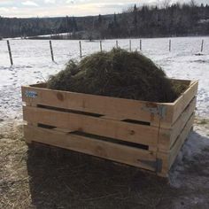 a wooden crate filled with hay in the snow