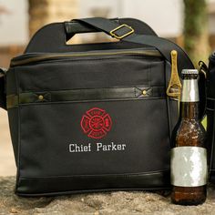 a black bag with a firefighter emblem and a beer bottle next to it on a stone surface