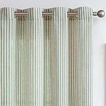 the curtains are hanging on the wall in front of the window, which is decorated with green and white striped fabric