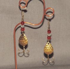 Hook a fisherman instead of a fish with this pair of fun, whimsical  earrings that look like fishing lures!  Handcrafted with a spinning blade, with red and crystal clear beads, gold ear wires, and even a handmade "fishhook"! Measures approximately 3" in length. Display stand not included. Stock #8605 Whimsical Earrings, Copper Heart, Clear Beads, Handcrafted Artisan Jewelry, Fishing Lure, Etsy Earrings Dangle, Hook Earrings, Fishing Lures, Display Stand