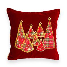 a red pillow with christmas trees on it