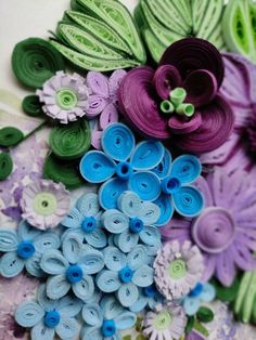 there are many different colors of flowers on this paper work piece that is made out of yarn