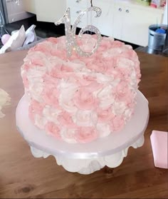 a pink and white cake sitting on top of a table