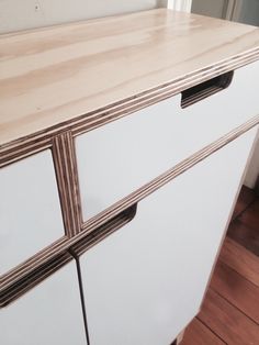 a white cabinet with two drawers on top of it