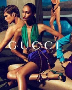 two women in swimsuits sitting on a couch with the words gucci above them