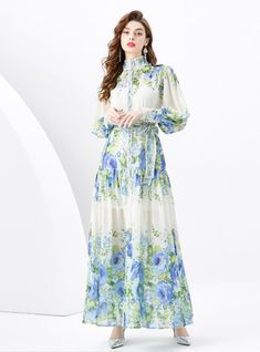 Oasis of Elegance: This stunning maxi dress is a true oasis for the eyes, flourishing with blue florals reminiscent of a serene, sunlit meadow. The lightweight fabric cascades gracefully from the demure, high-neck collar down to the soft, billowing hem, creating an impression of noble sophistication. With a tailored waist accented by a delicate belt, this dress offers a silhouette that's both flattering and enchanting. The full-length button placket adds a touch of classic charm, while the combination of sheer and opaque fabrics brings a modern twist to this timeless piece. Ideal for garden parties or elegant daytime events, this dress promises a look of refined beauty and an air of poetic poise. Fabric name: chiffonPattern: printingSkirt length: long skirtSleeve length: long sleevesColor: Flowy Floor-length Floral Dress For Garden Party, Flowy Long Floral Dress For Garden Party, Floor-length Flowy Floral Dress For Garden Party, Blue Bohemian Maxi Floral Dress, Flowy Maxi Floral Dress For Garden Party, Spring Bohemian Chiffon Midi Dress, Long Blue Midi Dress With Floral Print, Flowy Maxi Length Floral Dress, Blue Long Sleeve Maxi Dress For Garden Party