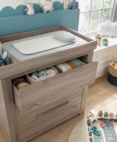 a baby's changing table with an open drawer