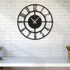 a clock is on the wall next to a desk and pencils in a vase