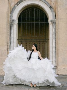 a woman in a white dress is standing outside