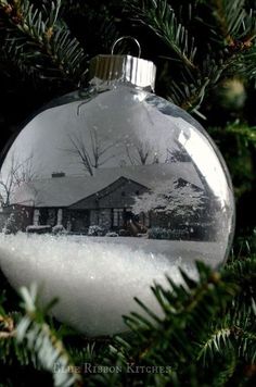 an ornament hanging from a christmas tree with snow on it's bottom