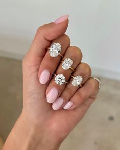 a woman's hand with three rings and two engagement rings on her fingers, one is