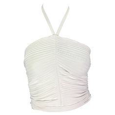 Presenting a form-fitting white Gucci cropped halterneck top, designed by Tom Ford. From the Spring/Summer 2000 collection, this ribbed top clings to the body. Featuring a seam down the front, this halterneck top naturally ruches and is made complete with a tie that wraps around the waist. Approximate measurements: Size - S Shoulder to hem: 15" Bust: 31" - 35" Waist: 24" - 30" (Can be tied even tighter) 83% Rayon Viscose, 17% Polyester Gucci Sleeveless Top For Summer, White Fitted Halter Neck Crop Top, Summer White Ribbed Halter Top, White Ribbed Halter Top For Summer, Fitted Ribbed Halter Neck Crop Top, White Fitted Halter Top For Evening, White Ribbed Halter Top For Spring, White Halter Neck Crop Top For Night Out, Fitted Ribbed Halter Top For Summer