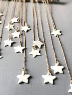 many white stars are hanging from strings on a table