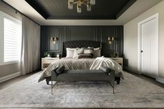 a bedroom with a large bed and chandelier hanging from it's ceiling