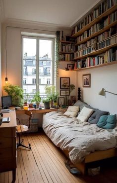 a bed sitting in the middle of a living room next to a book shelf filled with books