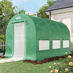 a large green house sitting on top of a lush green field