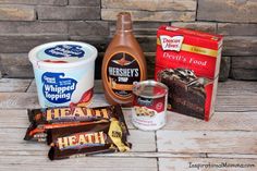 the ingredients for an ice cream dessert are displayed on a wooden table next to a brick wall