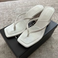 Never Worn. Comes In Original Box. White Trendy Toe Post Heels, Chic Cream Toe Post Sandals, White Toe Post Sandals With Padded Heel, White Toe Post Heels With Padded Heel, White Toe Post Formal Sandals, White Toe Post Heels For Formal Occasions, Formal White Toe Post Heels, Chic White Toe Post Heels, Logo Flip Flops