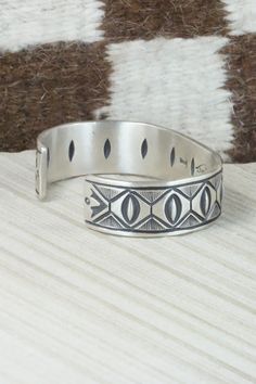 This sterling silver bracelet was made by Navajo silversmith Calvin Martinez. The inside is signed C MTZ, Navajo and stamped sterling.Size: 5 3/8" (will fit up to a 6 3/8" wrist)Gap: 1"Width: 5/8"Free shipping on all orders! We ship with USPS and always include tracking. All orders ship within a day of payment.Returns are accepted up to 30 days after you receive your order. Just send us a message. Our shop offers cash back or store credit. The item must be returned in new condition. Southwestern Silver Cuff Bracelet With Inlay, Sterling Silver Inlay Bracelets In Silver Color, Southwestern Style Etched Sterling Silver Bracelet, Sterling Silver Southwestern Bracelet, Adjustable Etched Sterling Silver Southwestern Bracelet, Artisan Sterling Silver Bracelet With Inlay, Adjustable Etched Southwestern Sterling Silver Bracelet, Southwestern Sterling Silver Stamped Bangle Bracelet, Southwestern Style Stamped Sterling Silver Bangle Bracelet