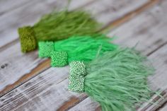 some green and white feathers are laying on a wooden surface