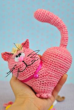 a hand holding a pink crocheted cat toy