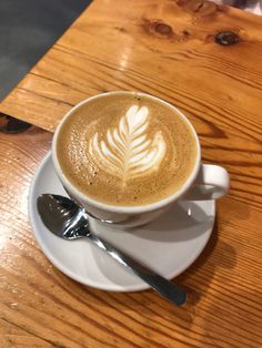 a cappuccino on a saucer with a spoon