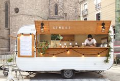 a man standing in front of a food truck with lights on it's side