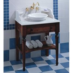 a bathroom sink sitting on top of a wooden stand next to a blue and white tiled wall