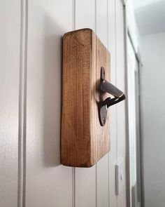 a pair of scissors hanging from a wooden hook on a white door with wood grained paneling