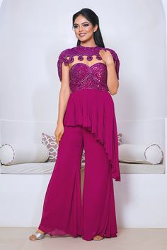 Wine peplum kurta with cutdana hand embroidered yoke and asymmetric hem. Paired with a plain sharara and cape with matching hand embroidery. - Aza Fashions Elegant Sleeveless Set For Reception, Elegant Sleeveless Reception Set, Elegant Purple Sharara For Party, Elegant Purple Reception Sets, Fitted Sleeveless Sharara For Party, Elegant Fitted Purple Sharara, Elegant Purple Sharara For Reception, Elegant Purple Sharara For Wedding, Festive Pink Sets For Wedding Guest