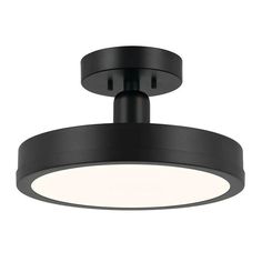 a black ceiling light that is on top of a white wall and has a circular light fixture