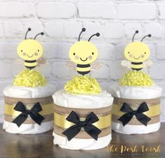 three diaper cakes with yellow and black decorations on them, one has a bee sitting on top