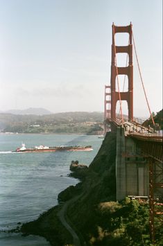 the golden gate bridge is over looking the water and boats in the bay below it