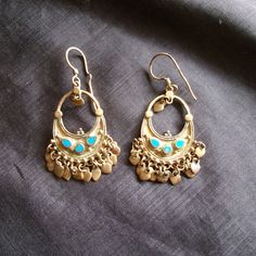 These vintage Afghani tribal style pierced earrings are really interesting with lots of detail. The metal is non magnetic and a golden brassy color. There are spots of tarnish or patina. I have not tried to clean these in any way.  The blue stones have flecks of gold color in them.  Zoom these pictures to get a good look.  They measure about 1.5 inches long not including the ear wire.  I have more vintage jewelry here: www.etsy.com/shop/badkittyvintagefinds?section_id=14398871&ref=shopsection_le Blue Brass Earrings For Festival, Blue Brass Earrings For Festivals, Traditional Turquoise Dangle Chandelier Earrings, Traditional Blue Danglers For Pierced Ears, Traditional Blue Danglers, Blue Metal Earrings With Latkans, Traditional Turquoise Earrings With Latkans, Turquoise Chandbali Earrings With Latkans, Blue Bohemian Earrings With Latkans