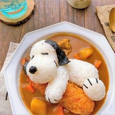 a white bowl filled with rice and some kind of dog shaped food on top of it