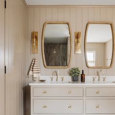 a bathroom with two sinks and mirrors on the wall