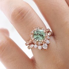 a close up of a person's hand wearing a ring with an aqua green stone