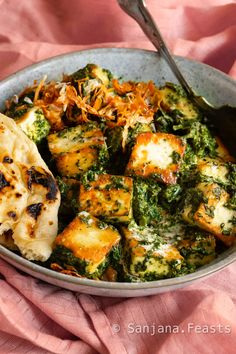 a bowl filled with tofu and broccoli covered in cheese