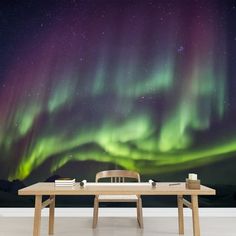 a table with two chairs under an aurora bore wallpaper mural in a dining room