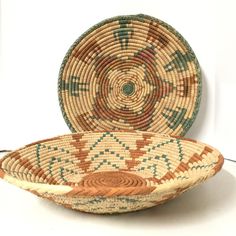 two baskets sitting next to each other on a white surface with one basket in the middle