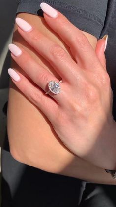 a woman's hand with pink manies and a diamond ring on her finger