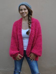 Hand knit Pink bomber jacket, over-sized chunky Hot Pink soft fuzzy cardigan, loose fitting sweater with puff sleeves. This cozy soft sweater is the perfect addition to complement your year round wardrobe. As the seasons change, and the morning/evenings become cooler, you will feel warm and cozy cuddled in this beautiful cardigan. I've created this sweater by knitting together strand of soft wool blend yarn, super soft Faux fur and mohair. It is very soft and comfortable with a lovely drapey loo Oversized Pink Knitted Outerwear, Pink Mohair Winter Outerwear, Pink Mohair Long Sleeve Outerwear, Oversized Knitted Pink Outerwear, Cozy Pink Mohair Outerwear, Pink Mohair Outerwear For Fall, Winter Chunky Knit Pink Outerwear, Pink Chunky Knit Outerwear One Size, Pink Chunky Knit Winter Outerwear