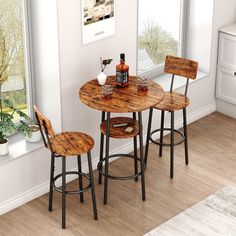 a kitchen table with two stools next to a window