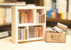 a book shelf with books and a wooden box on the table in front of it