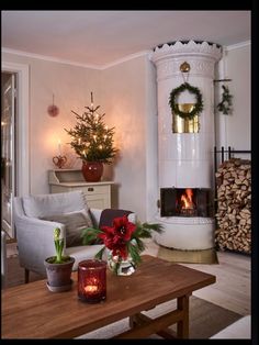 a living room filled with furniture and a christmas tree in the corner next to a fire place