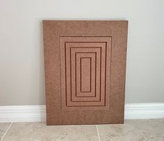 a brown frame sitting on top of a tile floor next to a white tiled wall