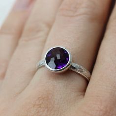 "This amethyst ring is such a simple, yet dazzling piece. Though the art deco band and protective tapered bezel stone setting make for a lovely ring, the real show stopper here is the deep amethyst stone, which has vibrant internal fire and a faceted top that enhances its sparkle even further. This stone is a generous 9mm, and it is well protected by its setting which envelops it on all sides. I do have other stones available, too, so let me know if you're interested in a quote for something els Art Deco Band, Stone Setting, Lovely Ring, Amethyst Stone, Amethyst Ring, Stackable Rings, Stone Settings, Gemstone Ring, Sapphire Ring